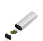 Electric Herb Grinder with Cap Removed Ground Green Herbs Spilling from the Open End on a White Surface - Australia E-cigarette Store