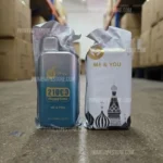 Two Vape Bottles in Clear Plastic Sleeves on a Warehouse Floor Left Bottle Labeled 210c3 Happytank Me  You Watermelon Ice Right Package Shows me  You with Mosque Dome Silhouettes - Australia E-cigarette Store